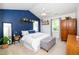 Relaxing bedroom features a vaulted ceiling, blue accent wall, ceiling fan, and plenty of natural light at 8009 Tobin Pl, Raleigh, NC 27612