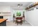Bright dining area with white walls, a large window, and hardwood floors adjacent to kitchen at 8009 Tobin Pl, Raleigh, NC 27612