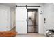 Open kitchen layout with a modern stainless steel refrigerator adjacent to a white sliding barn door at 8009 Tobin Pl, Raleigh, NC 27612