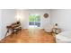 Bright living room with wood floors, a piano, and sliders to a deck with outdoor seating at 8009 Tobin Pl, Raleigh, NC 27612