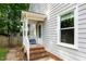 Side entry porch with brick steps and white painted railings and siding at 8009 Tobin Pl, Raleigh, NC 27612