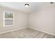 Bright bedroom featuring a large window and soft neutral carpet at 8013 Toddwick Ct, Raleigh, NC 27616