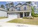 Two-story home with stone and gray siding and a two-car garage, providing an attractive curb appeal at 8013 Toddwick Ct, Raleigh, NC 27616