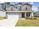 Charming two-story home with stone accents, a paved driveway, and a two-car garage at 8013 Toddwick Ct, Raleigh, NC 27616