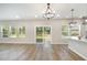 Open-concept living area with hardwood floors, large windows, and sliding glass doors to patio at 8013 Toddwick Ct, Raleigh, NC 27616