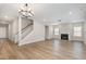 Open living room with hardwood floors, stairs, fireplace, and large windows at 8013 Toddwick Ct, Raleigh, NC 27616