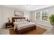 Bedroom with a wooden headboard, two windows, and two bedside lamps at 8013 Toddwick Ct, Raleigh, NC 27616