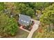 Aerial view of a home with mature trees and landscaping, featuring an outbuilding and driveway at 817 S Creek Dr, Nashville, NC 27856