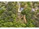Aerial view showcasing the home nestled among trees with a storage shed in the yard at 817 S Creek Dr, Nashville, NC 27856