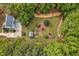 An aerial view reveals a charming property with lush gardens and a cozy outbuilding nestled amongst mature trees at 817 S Creek Dr, Nashville, NC 27856