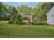 Lush backyard featuring a pergola, garden beds, and mature trees at 817 S Creek Dr, Nashville, NC 27856