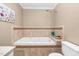 Bathroom showcasing a jetted tub with beautiful tile surround, a shower head, and toilet at 817 S Creek Dr, Nashville, NC 27856