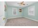 This light blue bedroom features neutral carpet, a ceiling fan, and multiple windows for ample natural light at 817 S Creek Dr, Nashville, NC 27856