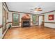 Spacious living room with a fireplace, hardwood floors, and natural light from large windows at 817 S Creek Dr, Nashville, NC 27856