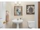 Cozy powder room features a pedestal sink, a framed mirror, and stylish decor at 817 S Creek Dr, Nashville, NC 27856