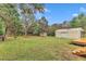 Spacious backyard featuring large metal outbuilding, storage shed, and wooden deck for outdoor enjoyment at 8201 Rhodes Rd, Apex, NC 27539