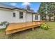 Expansive wooden deck featuring sliding glass doors to the home, nestled in a well-manicured backyard at 8201 Rhodes Rd, Apex, NC 27539