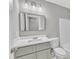 Bathroom features a modern vanity with a sleek mirror, updated fixtures and a white toilet at 8201 Rhodes Rd, Apex, NC 27539