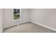 Bedroom featuring light tan walls, plush carpet, and a single window at 8201 Rhodes Rd, Apex, NC 27539
