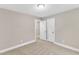 Bedroom featuring light tan walls, plush carpet, and access to hallway at 8201 Rhodes Rd, Apex, NC 27539