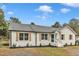 Charming white brick home with black mulch beds, shutters, and a neatly kept yard at 8201 Rhodes Rd, Apex, NC 27539