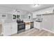 Well-lit kitchen features stainless steel appliances, white cabinets, and a stylish backsplash at 8201 Rhodes Rd, Apex, NC 27539