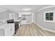 Spacious kitchen area featuring stainless steel appliances, light wood floors, and white cabinets at 8201 Rhodes Rd, Apex, NC 27539