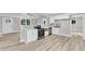 Open kitchen featuring stainless steel appliances, light wood floors, and light gray backsplash at 8201 Rhodes Rd, Apex, NC 27539