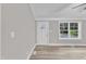 Bright open living area featuring white trim, light gray walls, and light wood floors at 8201 Rhodes Rd, Apex, NC 27539