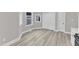 Living room with light gray walls, white trim and doors, and light wood floors at 8201 Rhodes Rd, Apex, NC 27539