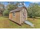 Charming storage shed featuring a ramp and a window, nestled in a verdant backyard at 8201 Rhodes Rd, Apex, NC 27539