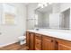 Bathroom features a single vanity with wood cabinets, a toilet, and a large mirror at 8525 Holdenby Trl, Raleigh, NC 27616