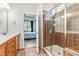 Bathroom featuring single vanity, glass shower with tile surround, and view into bedroom at 8525 Holdenby Trl, Raleigh, NC 27616