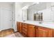 Bathroom featuring double vanity, large mirror, wooden cabinets, tiled floors, and walk-in shower at 8525 Holdenby Trl, Raleigh, NC 27616