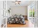 Cozy bedroom with hardwood floors, large windows, a ceiling fan, and a charming floral-patterned bedspread at 8525 Holdenby Trl, Raleigh, NC 27616