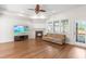 Inviting living room with fireplace, hardwood floors, and a comfortable sofa with a view of the backyard at 8525 Holdenby Trl, Raleigh, NC 27616