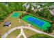 Aerial view of well maintained tennis courts and clubhouse within a mature tree landscape at 8525 Holdenby Trl, Raleigh, NC 27616