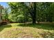 The backyard features a large shade tree and ample space, all enclosed by a wood fence at 928 Broadhaven Dr, Raleigh, NC 27603