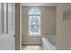 Bright bathroom features a soaking tub, stained glass window, and light, neutral paint at 928 Broadhaven Dr, Raleigh, NC 27603