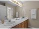 Bathroom features double sinks, a large mirror with vanity lighting, and neutral wall color at 928 Broadhaven Dr, Raleigh, NC 27603