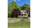 Traditional home with a welcoming front porch, set amidst mature trees and a stone retaining wall at 928 Broadhaven Dr, Raleigh, NC 27603