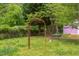 Spacious backyard with mature trees and lush greenery featuring an orange metal arbor at 107 Glosson Cir, Carrboro, NC 27510