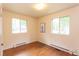 Bright bedroom with hardwood floors, two windows for ample natural light, and modern recessed ceiling lights at 107 Glosson Cir, Carrboro, NC 27510