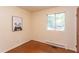 Cozy bedroom with hardwood floors, natural light from a window, and a cute panda art piece at 107 Glosson Cir, Carrboro, NC 27510