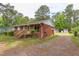 A cozy brick house is nestled among trees, offering a peaceful setting and a long driveway at 107 Glosson Cir, Carrboro, NC 27510