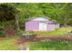 Charming backyard featuring a unique purple garage, outdoor seating, and beautiful garden daisies at 107 Glosson Cir, Carrboro, NC 27510