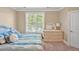 Bright bedroom with a wicker dresser, a large window, and patterned bedding, creating a relaxing atmosphere at 110 Tressel Way, Durham, NC 27707