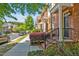 Street view of brick townhomes featuring manicured landscaping, black front doors, and a sidewalk at 110 Tressel Way, Durham, NC 27707