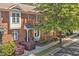 Well-maintained brick townhomes showcasing tidy landscaping, sidewalks, and tree-lined street at 110 Tressel Way, Durham, NC 27707