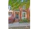 Close-up of a brick townhome with a black front door, lush landscaping, and an ADT security sign at 110 Tressel Way, Durham, NC 27707
